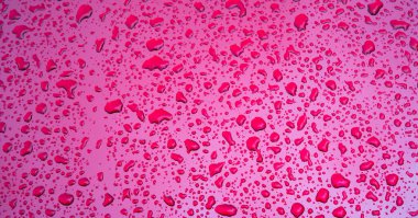 Metal bir yüzeye düşen yağmur damlalarının dokusuna sahip soyut kırmızı arkaplan