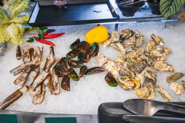 Asya 'daki otel restoranında açık büfede Asya deniz ürünleri. Vietnam 'da bir gece pazarında taze istiridye ve midye.