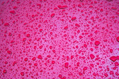 Metal bir yüzeye düşen yağmur damlalarının dokusuna sahip soyut kırmızı arkaplan