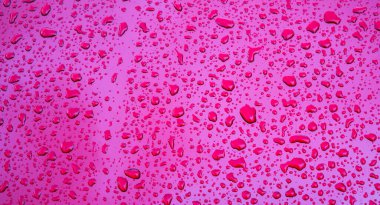 Mor metalik yüzeyde yağmur damlalarının dokusuyla kırmızı arkaplan