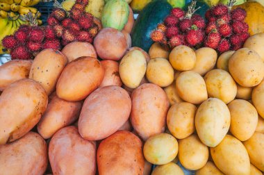 Tayland 'daki Asya pazarında çeşitli mango çeşitleri ve taze Asya egzotik meyveler tezgahta.