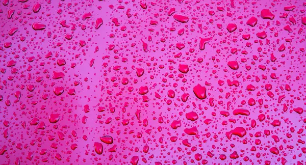 Mor metalik yüzeyde yağmur damlalarının dokusuyla kırmızı arkaplan