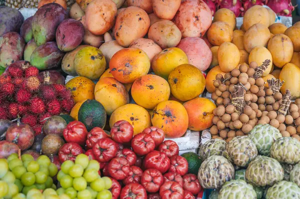 Tayland 'daki Asya sokak pazarının tezgahında taze Asya egzotik meyve çeşitleri.