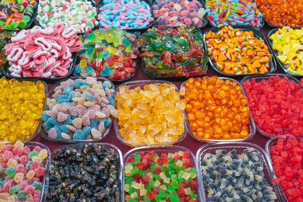 Doğu pazarındaki bir şeker dükkanının tezgahında çeşitli renkli marmelatlar ve çiğnenebilir şekerler var.