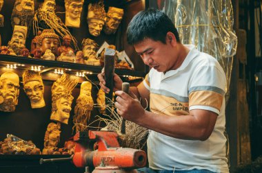 Asyalı erkek zanaatkar marangoz Vietnam 'ın Hoi An şehrindeki eski bir kasabada marangoz atölyesinde çalışıyor. Hoi An, Vietnam - 1 Aralık 2024