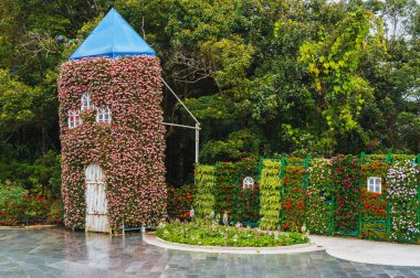 Parkta ya da evin arka bahçesinde bulunan canlı çiçeklerle kaplı kulenin resmi bir görüntüsü.