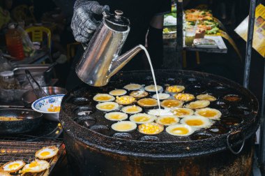 Vietnam 'da, Asya' daki bir sokakta, Asya 'daki bir gece pazarında geleneksel bir Vietnam yemeği pişirecekti.