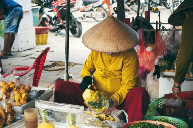 Vietnamlı kadın satıcı, Asya 'nın Hoi An kentindeki Asya pazarında meyve ve sebze satıyor.