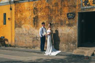 Vietnamlı gelin ve damat. Asya 'da, Hoi An' ın eski kasabasında, Asya 'da bir düğün töreninde birbirine aşık Asyalı bir çift. Hoi An, Vietnam - 1 Aralık 2024