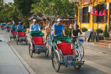 Geleneksel Asya Vietnam taşımacılığı Asya 'da Hoi An şehrinin eski kasabasının caddesinde bulunan bir bisiklet rickshaw' udur. Hoi An, Vietnam - 1 Aralık 2024