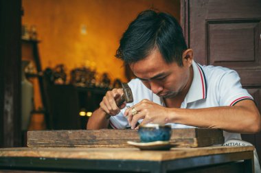 Vietnamlı Asyalı bir zanaatkar Vietnam 'da Hoi An şehrinde bir kuyumcu atölyesinde çalışıyor. Hoi An, Vietnam - 2 Aralık 2024
