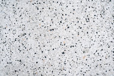 Siyah taş kırıntıları olan tahıllı beyaz doku. Kaldırım yüzeyinin deseni