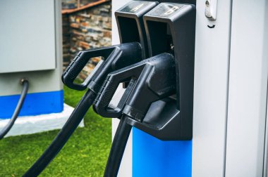 Elektrik şarj istasyonundaki kabloyu şarj eden elektrikli otomobiller için yakın plan.