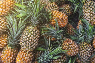 Egzotik ananaslı bir arka plan. Piyasada olgun tropikal meyveler