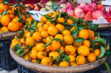 Asya 'da bir market tezgahında taze taze mandalina yığını.