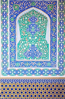 Özbekistan 'ın Taşkent kentindeki geleneksel Özbek süslemeleri ve renkli doğu desenleriyle boyanmış ahşap duvarın arka planı