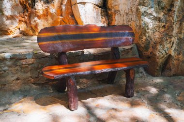 Park kompleksinin taş kaldırımında koyu kahverengi ahşaptan yapılmış bir bankın önü.