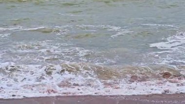 Kumlu bir sahilde muson mevsiminde kirli su ve büyük dalgalar. Yavaş çekim