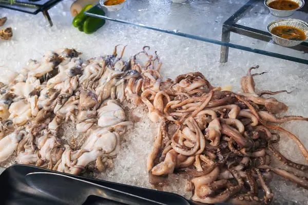 Restorandaki otelde açık büfede Asya deniz ürünleri. Vietnam 'da bir gece pazarında taze ahtapot ve mürekkep balığı.