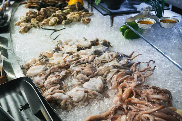 Asya 'daki restoranda Asya büfesinde deniz ürünleri. Vietnam 'da bir gece pazarında dondurulmuş taze ahtapot ve mürekkep balığı.