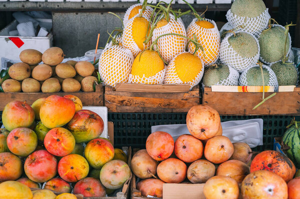 Ассортимент тропических фруктов на азиатском продовольственном рынке в Азии во Вьетнаме. Манго и вьетнамские спелые сладкие фрукты