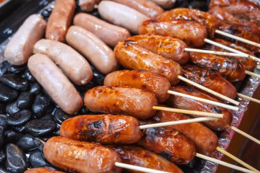 Asya gece pazarında kayaların üzerinde ızgara sosisler. Vietnam 'da Asya' da sokak yemekleri