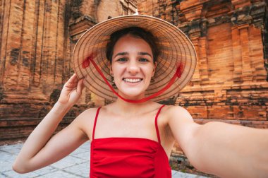 Vietnam 'da Vietnam' da Nha Trang, Vietnam 'da Po Nagar' ın Cham Towers 'ında selfie çeken Vietnamlı genç ve mutlu bir bayan turist.