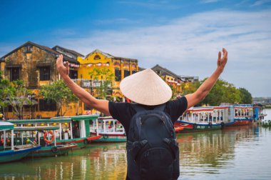 Vietnam 'da Hoi An' da Vietnam 'da bir köprüde Vietnamlı şapkalı mutlu bir turist.