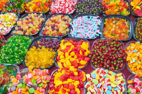Asya 'daki doğu pazarındaki şekerci dükkanının tezgahında çeşitli renkli marmelatlar ve çiğnenebilir şekerler var.