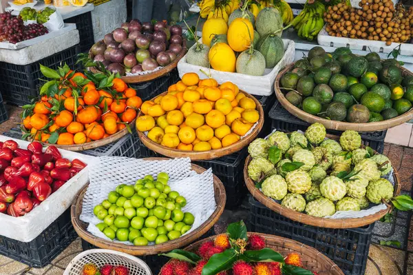 Vietnam 'daki Asya sokak pazarının tezgahında tropikal egzotik olgun Asya meyveleri var.