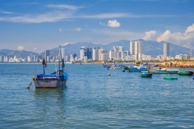 Nha Trang 'ın deniz manzarası ve renkli balıkçı tekneleriyle şehir manzarası.