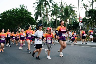 Nha Trang, Khanh Hoa Eyaleti, Vietnam - 11 Ağustos 2024: VnExpress Nha Trang Maratonu 'nda ana cadde boyunca koşan Asyalı yetişkin ve çocuklardan oluşan bir kalabalık.