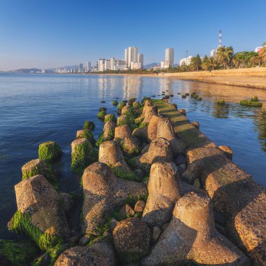 Vietnam 'da gökdelenleri olan Nha Trang şehrinde deniz kenarındaki setin ve yosun plajlarının manzarası.
