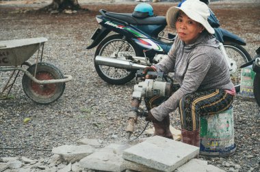 Yetişkin bir Vietnamlı kadın elektrikli matkapla inşaat alanında çalışıyor. Nha Trang, Vietnam - 16 Aralık 2024