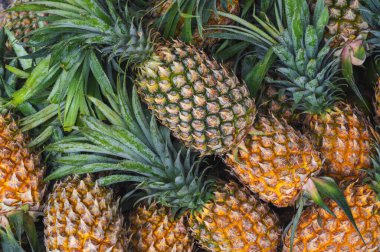 Doğal ananaslı arka plan. Market tezgahında olgun tropikal meyveler