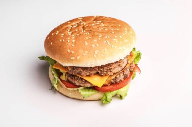 Beyaz arka planda hamburger. Kes ve doldur. Et ve salata. Fast food minimalizmi. Abur cubur. Kolesterol. Turba tahtası. Yemek standı Üst Manzara. Düz.