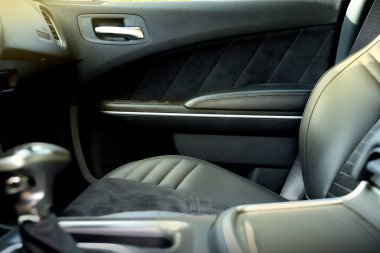 Modern bir arabanın siyah iç mekanı. Gösterge paneli. Lüks deri direksiyon. Otomatik kontroller. Arabanın kapıları içeride. Sandalyeler ve koltuklar. Araba koltuğu. Arka ve ön sıra. İç ve kapı süslemesi. Yüksek kalite