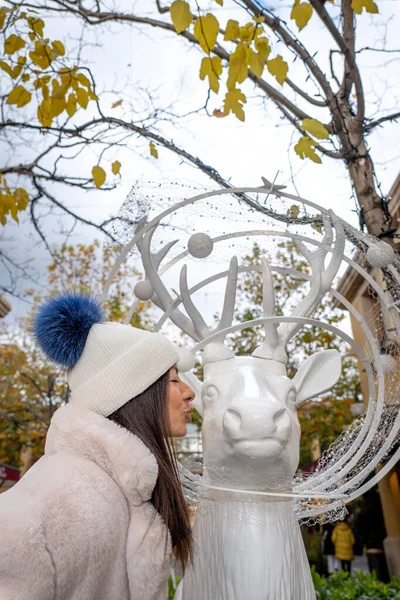 stock image Woman kissing a white deer at christmas