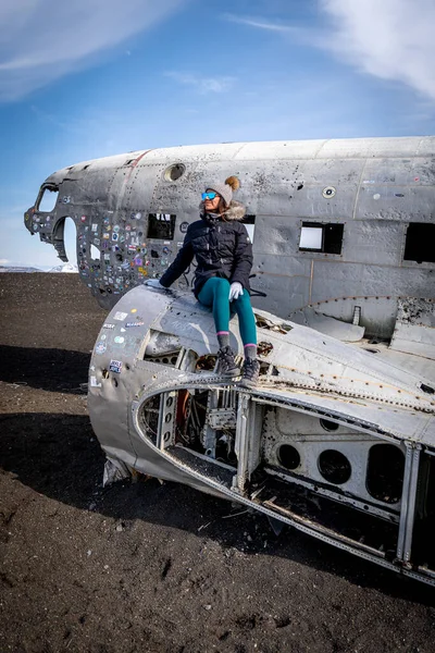 Woman posing in plane wreckage in Iceland