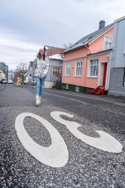 Reykjavik sokaklarında metalik gümüş ceketli bir kadın.