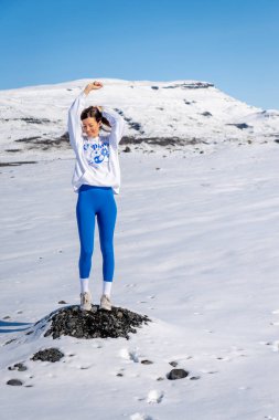 Güneşli bir günde, karın ortasında mutlu bir kadın.