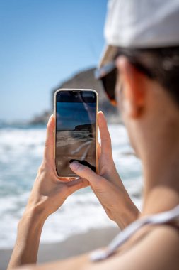 Beyaz Başlıklı Kadın Sahilden Denizin Fotoğrafını Çekiyor