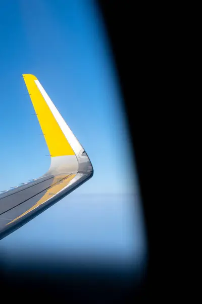 stock image Vertical View of Yellow Airplane Wing from Inside the Cabin