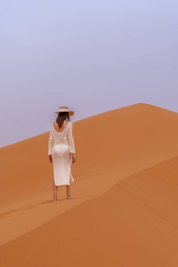 Beyaz Elbiseli ve Şapkalı Zarif Kadın Erg Chebbi Dunes, Fas