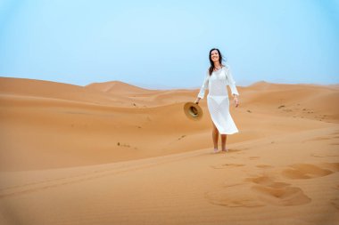 Deve Şapkalı Genç Esmer Kadın ve Beyaz Elbiseli Kadın Erg Chebbi Dunes, Fas 'ta