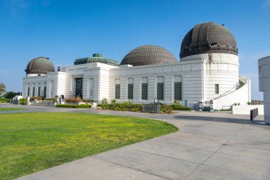 Etkileyici mimari tasarımı Los Angeles 'taki Griffith Gözlemevi' ni gözler önüne seren üç farklı ev şekilli çatıya sahip büyük ve çarpıcı bir beyaz bina.