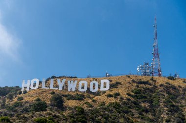 İkonik Hollywood tabelası, Los Angeles, Kaliforniya, ABD 'de cazibesini ve cazibesini artıran, gür ağaçlarla çevrili güzel manzaralı bir tepenin üzerinde konumlandırılmıştır.