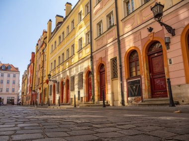 Wroclaw, Polonya 'daki kentsel karakterini gözler önüne seren canlı bir şehirde tuhaf bir kaldırım taşı caddesini kaplayan büyüleyici binalar dizisi.