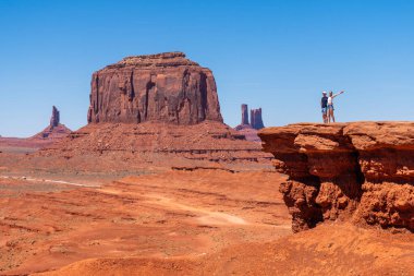 Anıt Vadisi 'ndeki John Ford Point' te gezgin bir çift. Yüksek kalite fotoğraf