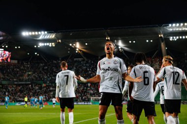 Steven Kapuadi  seen celebrating after scoring goal during UEFA Europa Conference League game between teams of  Legia Warszawa and Real Betis Balompie  at Stadion Miejski Legii Warszawa (Maciej Rogowski) clipart